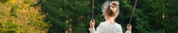 Little girl swinging on a swing.