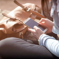 Woman using her phone to make a mobile deposit.