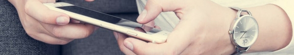 Close-up of hands texting on mobile phone.