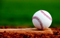 Baseball sitting on dirt in the baseball field.