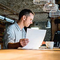 Business owner doing paperwork on bar top.