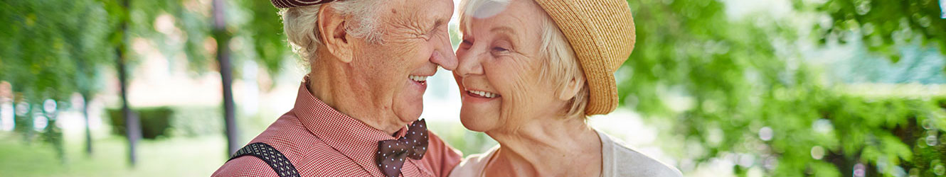 Retired couple enjoying flowers in garden.