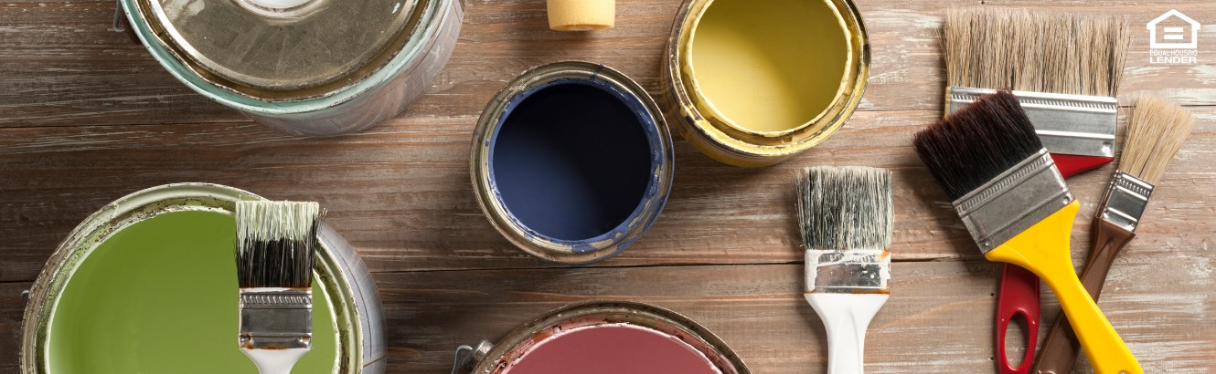 Group of different colored paint cans with paint brushes.
