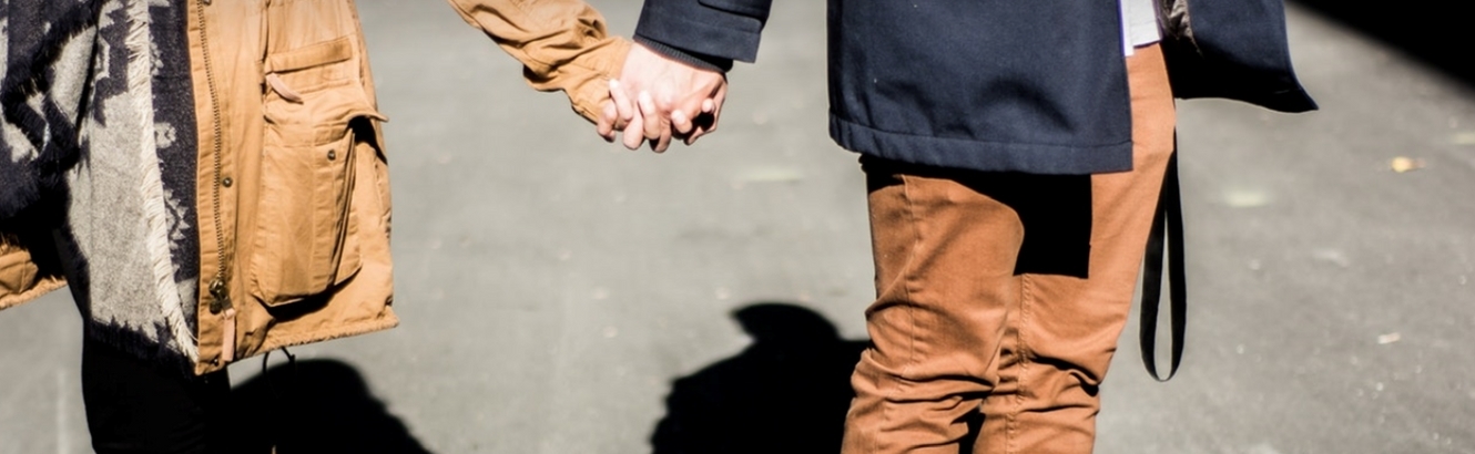 Couple holding hands on the street.