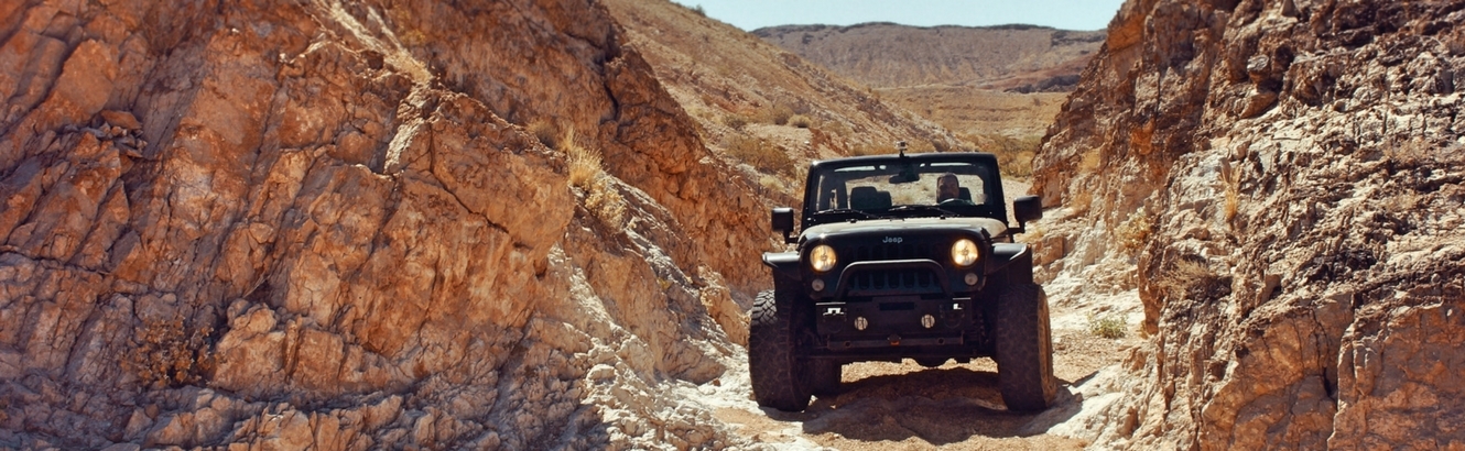 Jeep driving off-road through boulders.