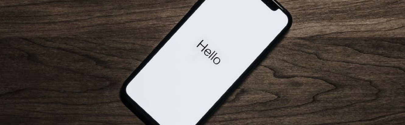 New phone laying on table with "Hello" on the screen