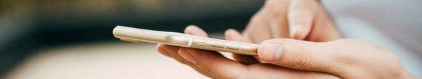 Close-up of a person's hands using a cell phone.