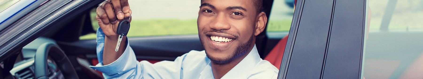 Man sitting in his car and holding car keys