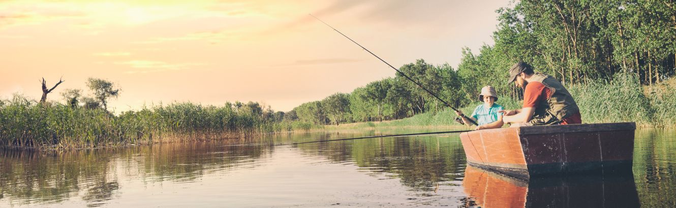 Man and son fishing in a boat on a river