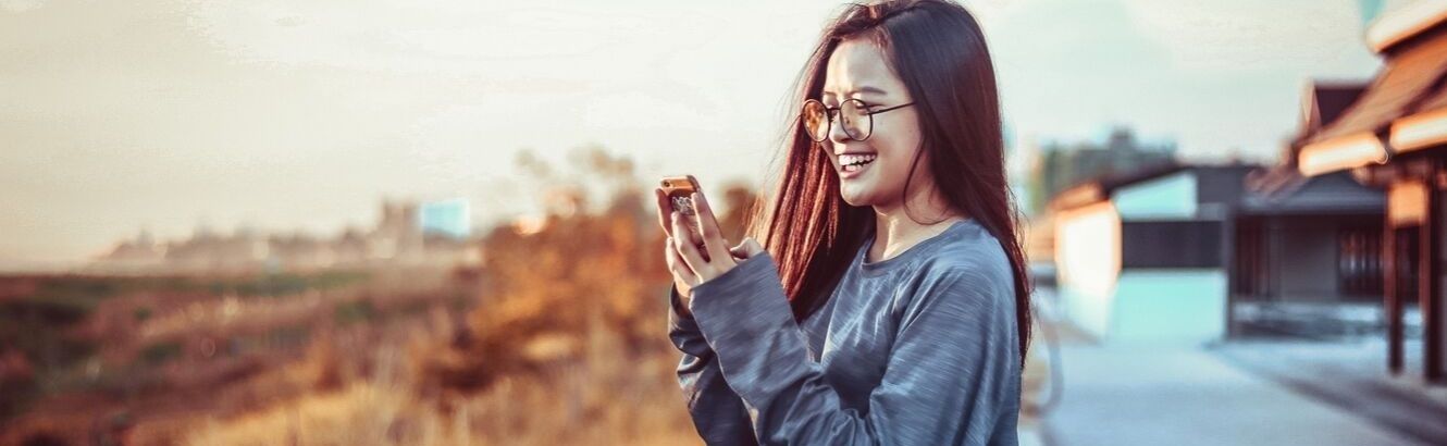 Girl sitting outside and looking at her phone.