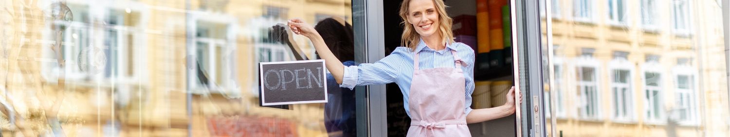 Woman hanging an Open sign on her business