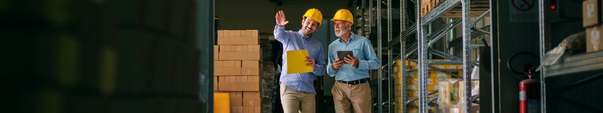 Two contractors talking in a warehouse